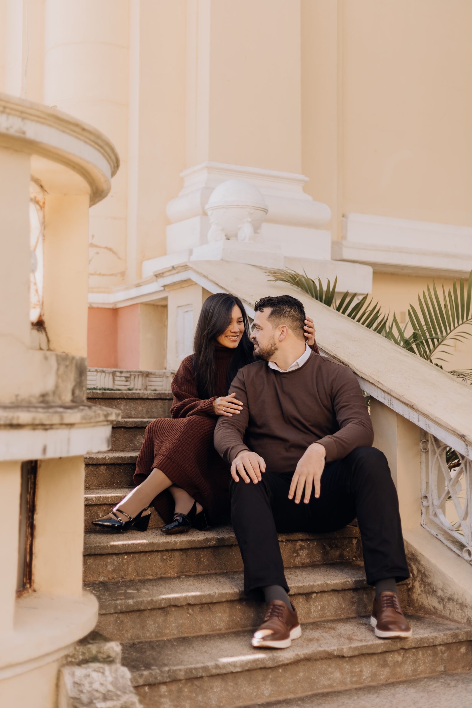 Ingrid e Víctor sorrindo, abraçados em uma escadaria